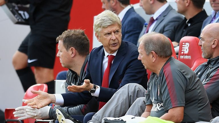 Arsene Wenger, Manager of Arsenal speaks to his staff during the Premier League match between Liverpool and Arsenal at Anfield