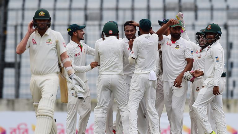 Bangladeshi cricketer Shakib Al Hasan (C) celebrates with his teammates after the dismissal of Australian cricketer Nathan Lyon (L) during the first day of