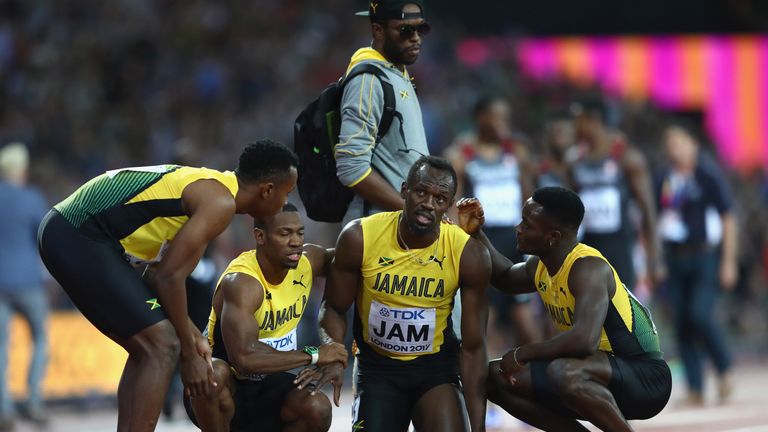 LONDON, ENGLAND - AUGUST 12:  Usain Bolt of Jamaica is helped up by teammmates Tyquendo Tracey, Julian Forte and Michael Campbell after falling in the Men'