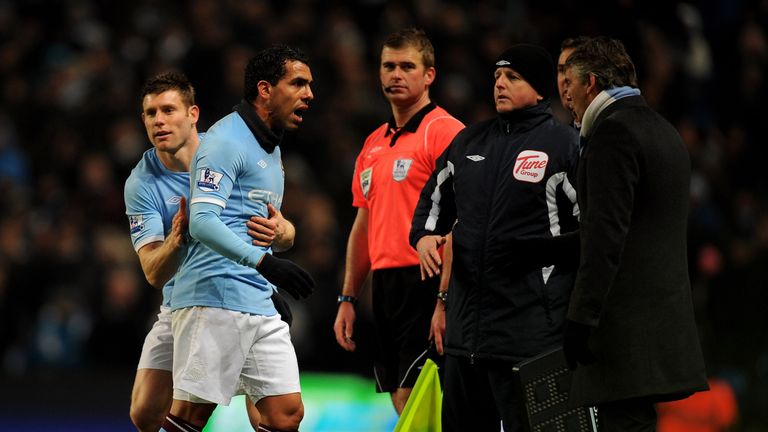 MANCHESTER, ENGLAND - DECEMBER 04:  Carlos Tevez of Manchester City has words with Manchester City Manager Roberto Mancini after being substituted for team