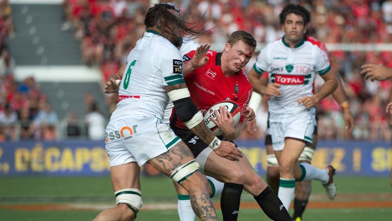 RC Toulon's English winger Chris Ashton (C) is tackled by Pau's French flanker Pierrick Gunther (L)  27.08.2017