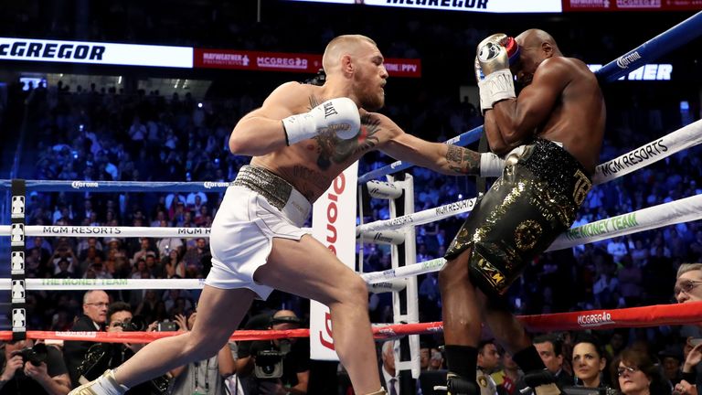 Conor McGregor throws a punch at Floyd Mayweather Jr in the opening round