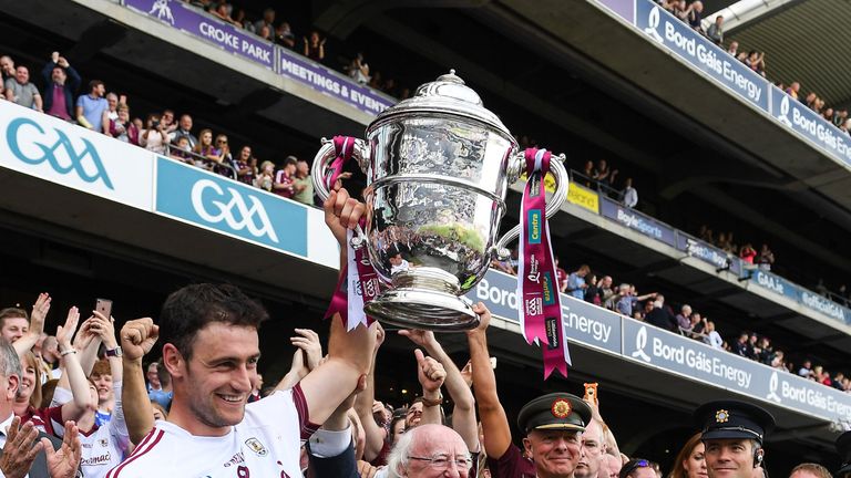 The President of ireland Michale D Higgins and the Galway captain David Burke lift the Bob O'Keeffe Cup