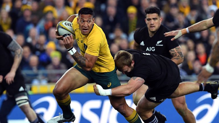 Israel Folau (C) is tackled by New Zealand's hooker Codie Taylor