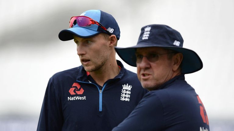 England's captain Joe Root (L) and coach Trevor Bayliss chat during the England cricket team's training session at 