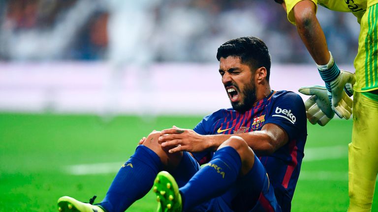 Luis Suarez grimaces while holding his knee during the Spanish Super Cup, Second Leg