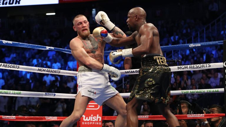 Floyd Mayweather Jr. throws a punch at Conor McGregor during their super welterweight boxing match on August 26, 2017.