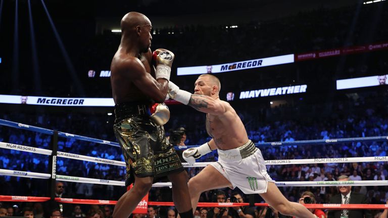 Conor McGregor throws a punch at Floyd Mayweather Jr. during their super welterweight boxing match on August 26, 2017