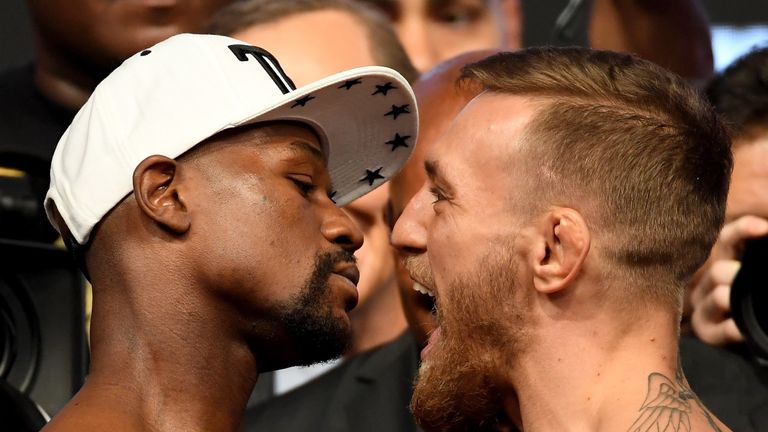Boxer Floyd Mayweather Jr. (L) and UFC lightweight champion Conor McGregor face off during their official weigh-in at T-Mobile  Arena