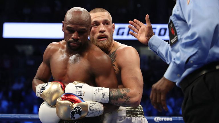 Floyd Mayweather Jr. and Conor McGregor tie up during their super welterweight boxing match on August 26, 2017 at T-Mobile Arena