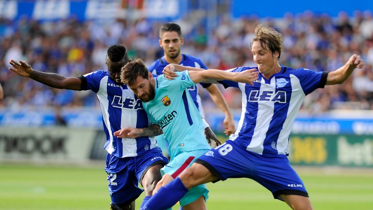 Barcelona's Argentinian forward Lionel Messi (C) vies with Deportivo Alaves' Ghanaian forward Wakaso Mubarak (L) and midfielder Tomas Pina (R) during the S