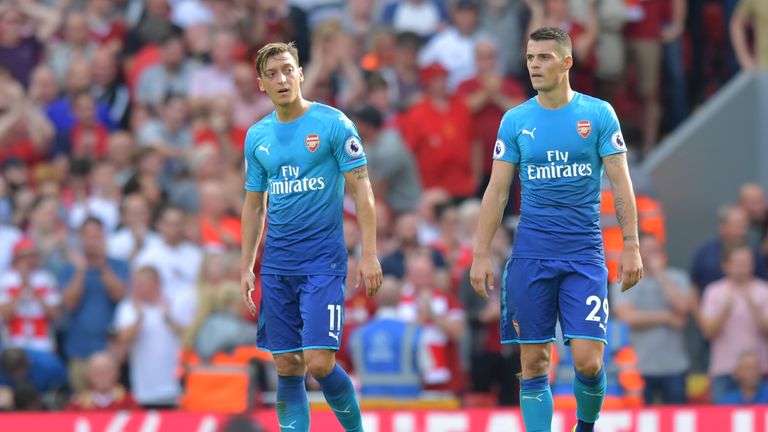 Arsenal's German midfielder Mesut Ozil (L) and Arsenal's Swiss midfielder Granit Xhaka react after conceding against Liverpool