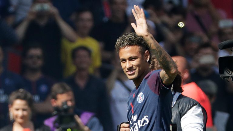 Paris Saint-Germain's Brazilian forward Neymar waves to the crowd as he arrives on the football field during his presentation to the fans at the Parc des P