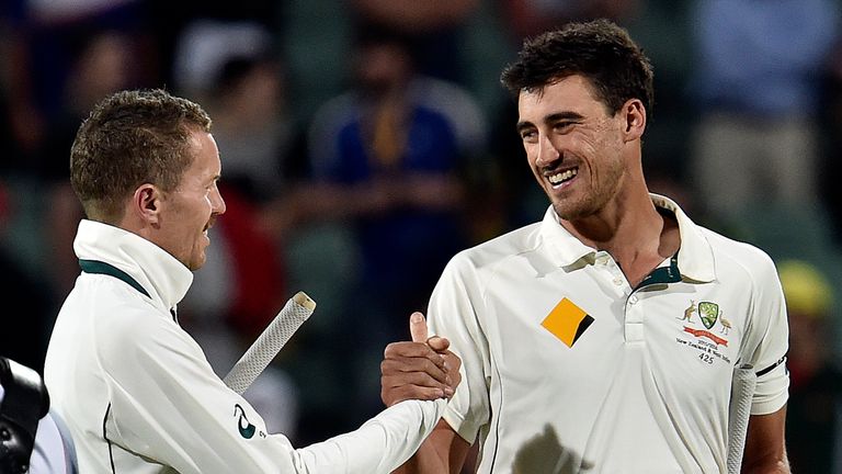 Australia's unbeaten pair Peter Siddle (L) and Mitchell Starc celebrate victory against New Zealand at the end of first day-night cricket Test match at the