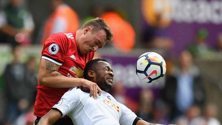 Phil Jones gets above Jordan Ayew as they battle for possession at the Liberty Stadium