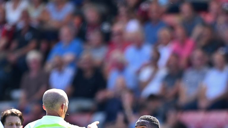 Manchester City midfielder Raheem Sterling (R) gestures to referee Mike Dean after he receives a second yellow card for going into the crowd at Bournemouth