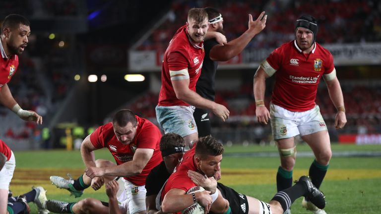 AUCKLAND, NEW ZEALAND - JUNE 24:  Rhys Webb of the Lions barges past Scott Barrett of the All Blacks to score his team's second try during the first test m