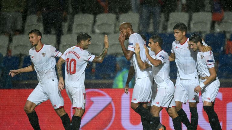 Sevilla's defender Sergio Escudero (L) celebrates with his teammates after scoring a goal during the UEFA Champions League play-off first leg football matc