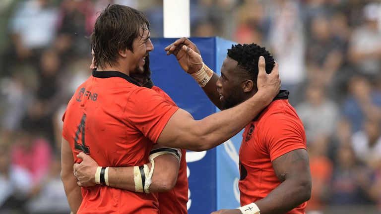 South Africa's flanker Siya Kolisi (R) celebrates with lock Eben Etzebeth (L) and  lock Franco Mostert after scoring his team's third try.