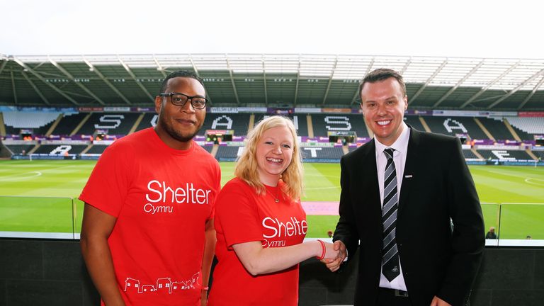 Letou CEO Paul Fox (R) with Sheter Cymru Charity during the English Premier League soccer match between Swansea City and Manchester United at Liberty Stadi