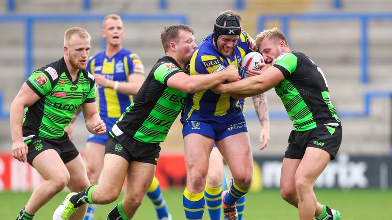 Warrington's Chris Hill is tackled by Halifax's Ben Kaye and Brandon Moore