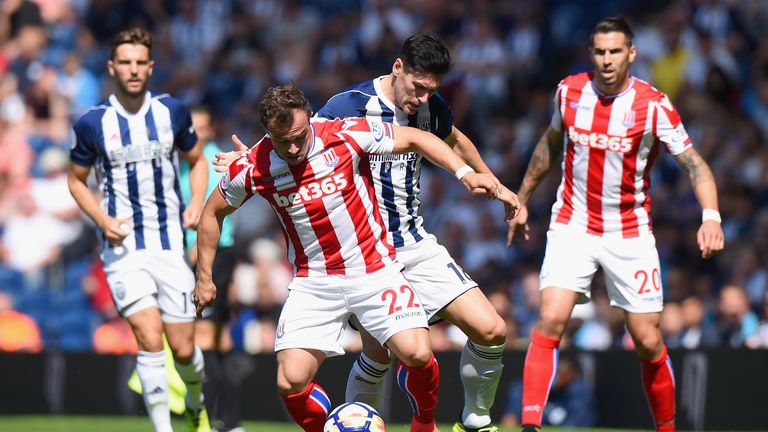 Xherdan Shaqiri and Gareth Barry challenge for the ball in the first half