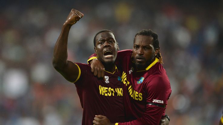 Carlos Brathwaite of the West Indies celebrates with Chris Gayle of the West Indies after dismissing Joe Root of England 