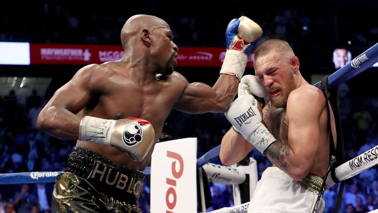 LAS VEGAS, NV - AUGUST 26:  (L-R) Floyd Mayweather Jr. throws a punch at Conor McGregor during their super welterweight boxing match on August 26, 2017 at 