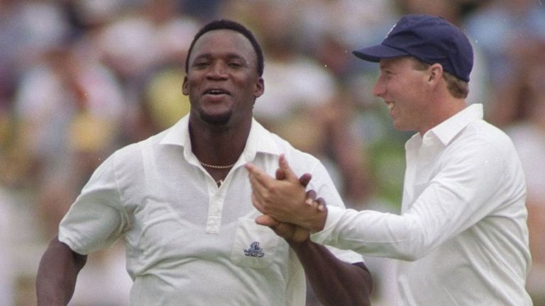 Jamaican-born Devon Malcolm is congratulated by England team-mate Mike Atherton in 1990