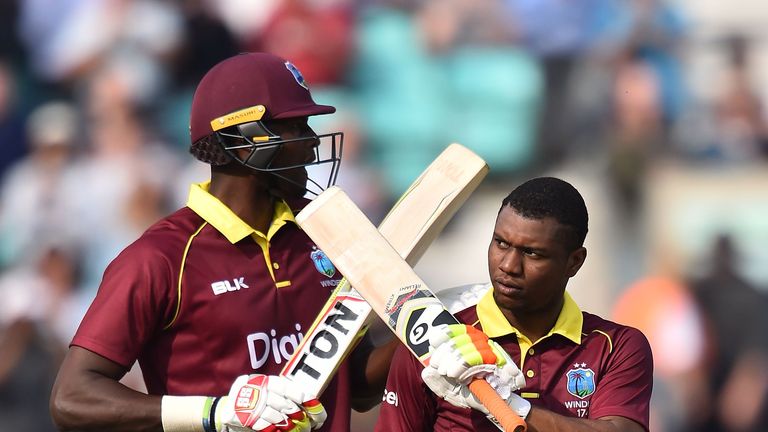 West Indies' Evin Lewis (R) celebrates with West Indies' Jason Holder after reaching his century during the fourth One-Day International (ODI) cricket matc