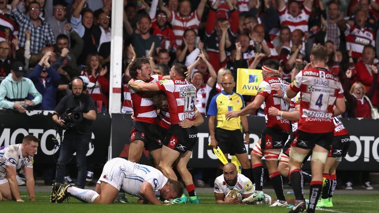 Jason Woodward of Gloucester is mobbed by team mates after scoring the match winning try