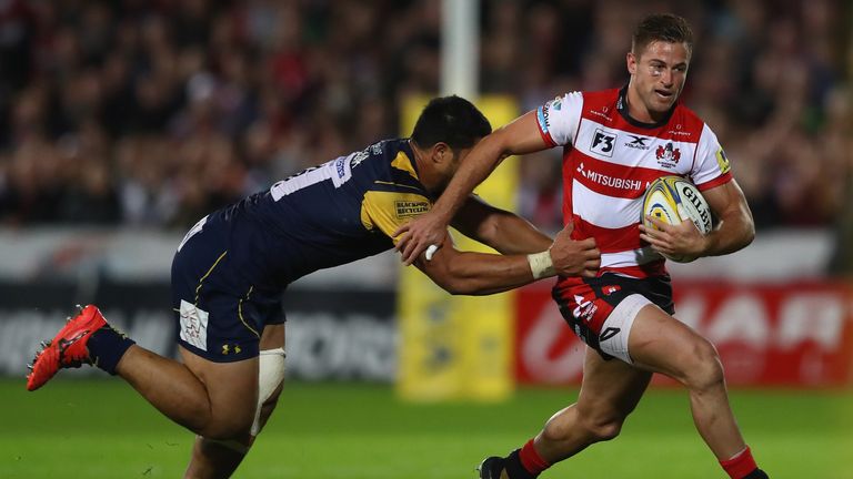 Henry Trinder of Gloucester is held up by Alafoti Faosiliva of Worcester Warriors 
