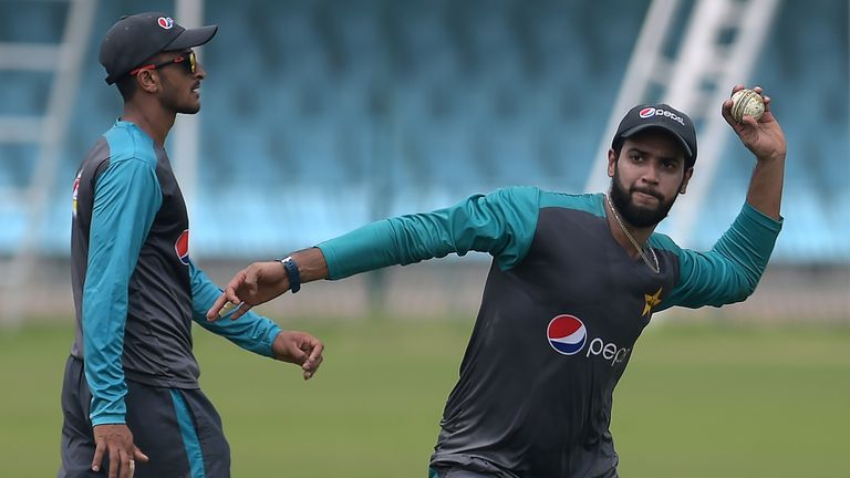 Pakistani cricketers Imad Wasim (R) throws the ball as teammate Hasan Ali looks on during a practice session at the Gaddafi Cricket Stadium in Lahore on Se