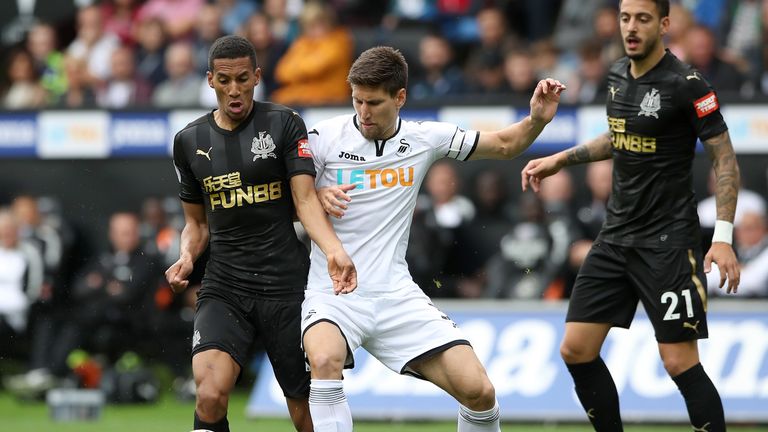 Newcastle United's Isaac Hayden (left) and Swansea City's Federico Fernandez (centre) battle for the ball during the Premier League match at the Liberty St