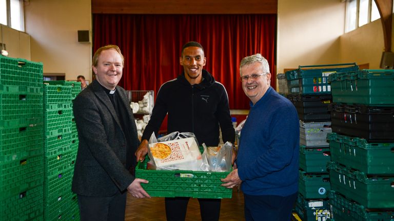 NEWCASTLE, ENGLAND - SEPTEMBER 14: Isaac Hayden (C) of Newcastle United poses for photos with Reverend Dominic Coad (L) Vicar of Church of the Venerable Be
