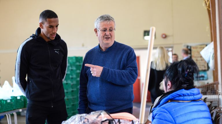 NEWCASTLE, ENGLAND - SEPTEMBER 14: Isaac Hayden of Newcastle United talks with Foodbank CEO Mike Nixon during a visit to Newcastle West End Foodbank