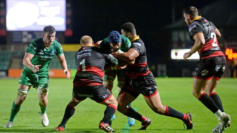 Connacht's John Muldoon is tackled by Dragons' Leon Brown and Brok Harris.