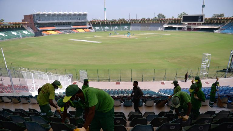 This picture taken on September 7, 2017 shows workers cleaning the seats of the Gaddafi Stadium in Lahore. 
Groundsmen are rolling down the pitches, welder