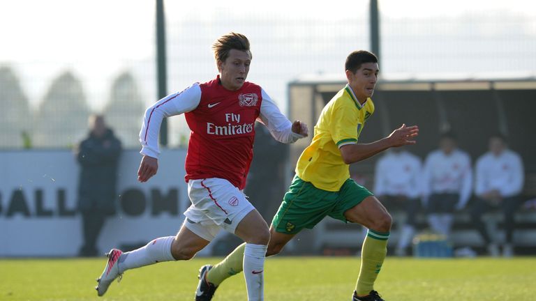 Luke Freeman of Arsenal races onto the ball chased by Harry Barker of Norwich