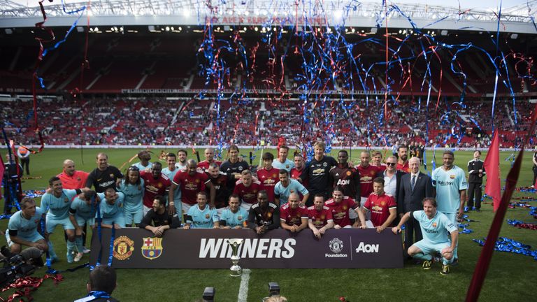MANCHESTER, ENGLAND - SEPTEMBER 02: Manchester United and Barcelona Legends celebrate with the trophy during the match between Manchester United Legends an
