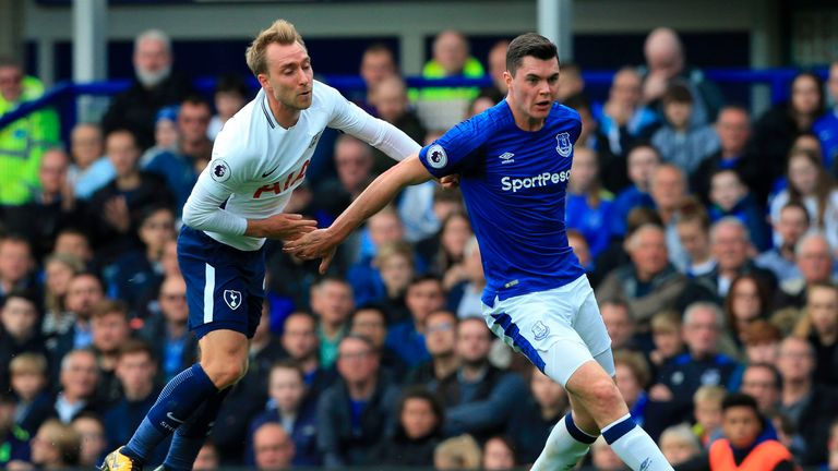 Everton's English defender Michael Keane (R) passes the ball under pressure from Tottenham Hotspur's Danish midfielder Christian Eriksen (L) during the Eng