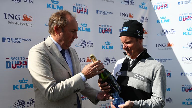 SPIJK, NETHERLANDS - SEPTEMBER 15:  Miko Ilonen of Finland is presented with a trophy by KLM Open Tour Director Daan Slooter after hitting the 1000th Europ