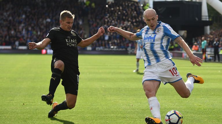 Huddersfield Town's Australian midfielder Aaron Mooy (R) crosses the ball as Leicester City's English midfielder Marc Albrighton tries to block during the 