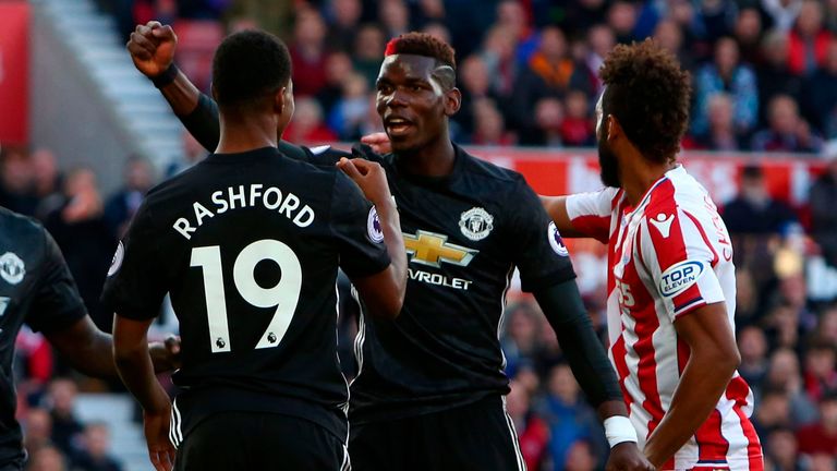 Manchester United's French midfielder Paul Pogba (C) celebrates after his header deflected off Manchester United's English striker Marcus Rashford (L) into