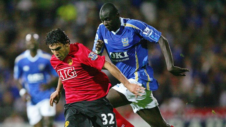 Manchester United's new Argentinian signing Carlos Tevez (L) vies for the ball against Portsmouth captain Sylvain Distin during their Premiership football 
