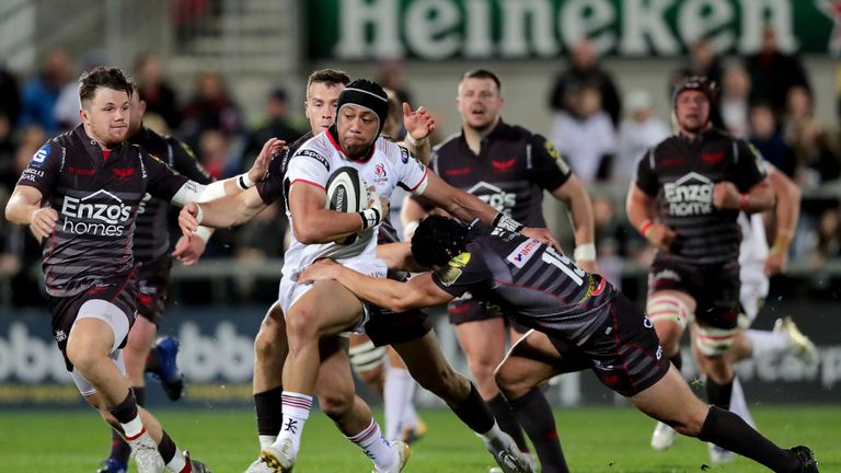 Christian Lealiifano is tackled by Scarlets full-back Leigh Halfpenny