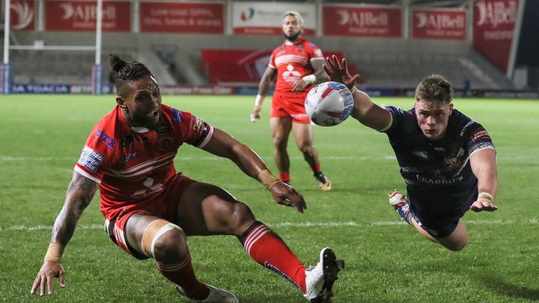 Morgan Knowles of St Helens and Manu Vatuvei of Salford Red Devils challenge for the ball
