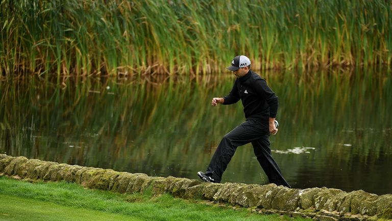 Sergio Garcia of Spain climbs over a wall on the 14th hole during day two of the British Masters at Close House