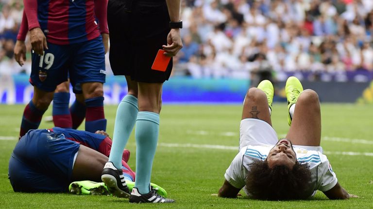 Real Madrid's Brazilian defender Marcelo (R) lies on the field during the Spanish Liga football match Real Madrid vs Levante at the Santiago Bernabeu stadi