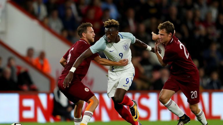 BOURNEMOUTH, ENGLAND - SEPTEMBER 05:  Tammy Abraham of England goes past Kriss Karklins and Eduards Emsis of Latvia during the UEFA Under 21 Championship Q